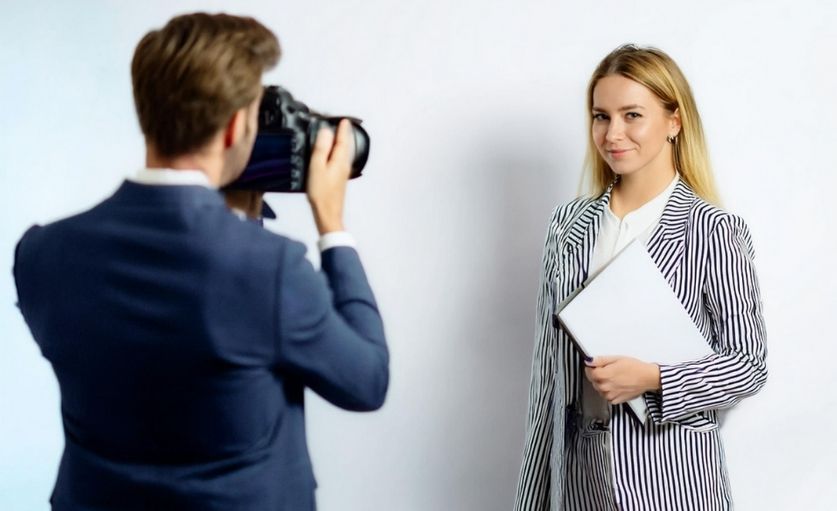 Jeune femme blonde en tenue professionnelle avec un photographe brun de dos